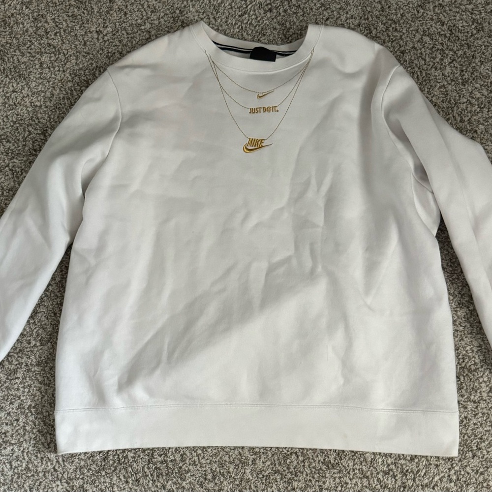 White Nike Crewneck with gold detail and a couple spots